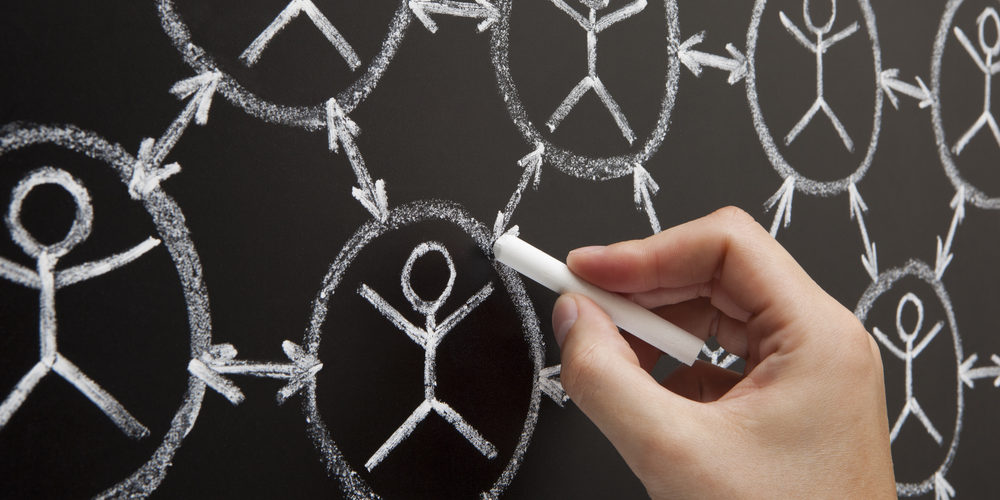 Hand showing social networking concept made with white chalk on a blackboard